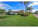 Manicured lawn with palm trees, and lush foliage surrounding this beautiful home at 520 74Th St, Holmes Beach, FL 34217