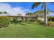 Beautiful home featuring a well-manicured lawn, lush landscaping, and a brick driveway at 520 74Th St, Holmes Beach, FL 34217