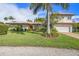 Beautiful home featuring a well-manicured lawn, lush landscaping, and a brick driveway at 520 74Th St, Holmes Beach, FL 34217