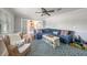 Cozy room with plush blue sofa, patterned rug, and wicker chair near glass doors at 520 74Th St, Holmes Beach, FL 34217