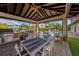 Outdoor kitchen with grill, dining table and seating, overlooking pool and canal at 520 74Th St, Holmes Beach, FL 34217