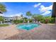 Beautiful backyard pool area with well-maintained landscaping, palm trees, and clear blue sky at 520 74Th St, Holmes Beach, FL 34217