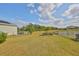 Spacious backyard surrounded by a white fence, featuring lush greenery and plenty of space for recreation at 5232 Wishing Arch Dr, Apollo Beach, FL 33572