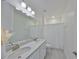 Bright bathroom featuring double sinks, a large mirror, and a shower with a white curtain at 5232 Wishing Arch Dr, Apollo Beach, FL 33572
