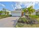 Beautiful two-story home featuring a two-car garage, lovely landscaping, and vibrant palm trees at 5232 Wishing Arch Dr, Apollo Beach, FL 33572