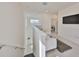 Hallway with white walls, plush rug, cozy white couch, and stairs down to marble floor at 5232 Wishing Arch Dr, Apollo Beach, FL 33572