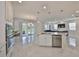 Bright kitchen with marble floors, stainless appliances, and an island overlooking the living area at 5232 Wishing Arch Dr, Apollo Beach, FL 33572