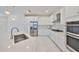 Modern kitchen featuring stainless steel appliances, sleek white cabinetry, and a spacious island at 5232 Wishing Arch Dr, Apollo Beach, FL 33572