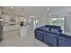 Open kitchen and living area with a large blue sectional and white cabinets and countertops at 5232 Wishing Arch Dr, Apollo Beach, FL 33572