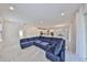 Bright living area with a large blue sectional, white walls, and marble flooring throughout at 5232 Wishing Arch Dr, Apollo Beach, FL 33572