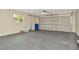 Spacious garage with smooth painted floor and a metal door at 5749 Southernview Dr, Zephyrhills, FL 33541