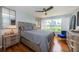 Cozy bedroom with a gray bed, wooden floors, and large windows with plantation shutters at 5900 Bahia Del Mar Cir # 137, St Petersburg, FL 33715