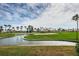 Picturesque view of a lush golf course with clear water and palm trees against a blue sky at 5900 Bahia Del Mar Cir # 137, St Petersburg, FL 33715