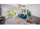 Inviting living room with a blue sofa, gray armchairs, and sliding glass doors to a patio at 5900 Bahia Del Mar Cir # 137, St Petersburg, FL 33715