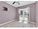 A bright, empty bedroom with light wood floors, a ceiling fan, and French doors to the outdoor area at 6618 3Rd N Ave, St Petersburg, FL 33710