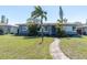 Charming single-story home with a well-manicured lawn and tropical landscaping, creating a welcoming curb appeal at 6618 3Rd N Ave, St Petersburg, FL 33710