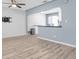 An open-concept living room with wood-look floors and a view into the kitchen area at 6618 3Rd N Ave, St Petersburg, FL 33710