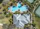 Aerial view showcasing community pool, clubhouse, tennis courts, and palm trees at 7100 Islamorada Cir, Seminole, FL 33777