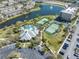 Aerial view of community amenities, including a pool, tennis courts, and a serene pond with fountains at 7100 Islamorada Cir, Seminole, FL 33777
