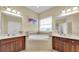 Bathroom with a central soaking tub, dual sinks, and abundant natural light at 7100 Islamorada Cir, Seminole, FL 33777