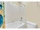 Bathroom featuring a tub with white tiled walls and a toilet at 7100 Islamorada Cir, Seminole, FL 33777