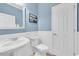 Charming powder room features a pedestal sink, wainscoting, and a fresh, clean aesthetic at 7100 Islamorada Cir, Seminole, FL 33777