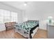 A cozy bedroom with wood floors, a ceiling fan, a comfy bed, and natural light at 7100 Islamorada Cir, Seminole, FL 33777