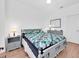 Neutral-toned bedroom features a gray bed frame and light wood floors at 7100 Islamorada Cir, Seminole, FL 33777