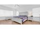 Bright bedroom featuring wood floors, white trim, and a large white bed frame at 7100 Islamorada Cir, Seminole, FL 33777
