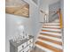 Welcoming entryway featuring a staircase and a charming welcome table and beach-themed decor at 7100 Islamorada Cir, Seminole, FL 33777