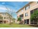 Rear exterior view of condo, featuring screened patio, lawn and lush landscaping at 7100 Islamorada Cir, Seminole, FL 33777
