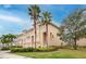 Townhome exterior showcasing front entrances, garages, palm trees and manicured landscaping at 7100 Islamorada Cir, Seminole, FL 33777