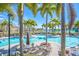Community pool area with tables, lounge chairs, palm trees and beautiful landscaping at 7100 Islamorada Cir, Seminole, FL 33777