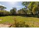 Expansive backyard with lush lawn, mature trees, and brick-edged garden beds at 724 69Th S Ave, St Petersburg, FL 33705