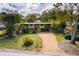 Aerial view of a two-story home featuring a gravel driveway and lush landscaping at 724 69Th S Ave, St Petersburg, FL 33705