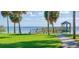 Picturesque pier with seating for fishing and waterfront views, framed by swaying palm trees at 724 69Th S Ave, St Petersburg, FL 33705