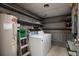 Basement laundry room with washer, dryer, hot water tank, storage shelves and concrete block walls at 724 69Th S Ave, St Petersburg, FL 33705