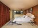 Bedroom with wood paneled walls, light neutral bedding, and natural lighting at 724 69Th S Ave, St Petersburg, FL 33705