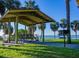 Scenic waterfront picnic area featuring covered shelter, seating, and grilling station with palm tree views at 724 69Th S Ave, St Petersburg, FL 33705