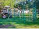 Community playground with slides and climbing structures surrounded by lush greenery and mature trees at 724 69Th S Ave, St Petersburg, FL 33705