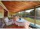 Covered porch features tile flooring, comfortable seating, and views of the yard at 724 69Th S Ave, St Petersburg, FL 33705