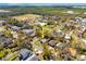 An aerial view of a charming property with a green roof, surrounded by mature trees in a residential neighborhood at 7415 S Obrien St, Tampa, FL 33616