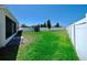 Expansive backyard with lush green grass and white fence, offering privacy and space for outdoor activities at 8220 Round Leaf Ln, Riverview, FL 33578