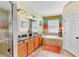 Bright bathroom with double sinks, soaking tub, and glass shower, enhanced by colorful accents at 8220 Round Leaf Ln, Riverview, FL 33578
