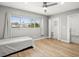 Bright bedroom featuring hardwood floors, a ceiling fan, and a large window with natural light at 8303 Bardmoor Blvd # 105, Seminole, FL 33777