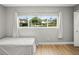 Bright bedroom featuring a large window with natural light, hardwood floors, and neutral decor at 8303 Bardmoor Blvd # 105, Seminole, FL 33777