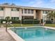 Community pool with a brick surround and a lounge chair with a low-rise building in the background at 8303 Bardmoor Blvd # 105, Seminole, FL 33777