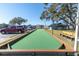 Well-maintained bocce ball court with benches and mature trees, perfect for outdoor recreation at 9790 66Th N St # 469, Pinellas Park, FL 33782