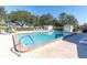 Relaxing community pool with lounge chairs and mature trees offering shade at 9790 66Th N St # 469, Pinellas Park, FL 33782