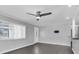 Well-lit living room featuring wood-look floors, modern ceiling fan, and ample natural light at 9790 66Th N St # 469, Pinellas Park, FL 33782